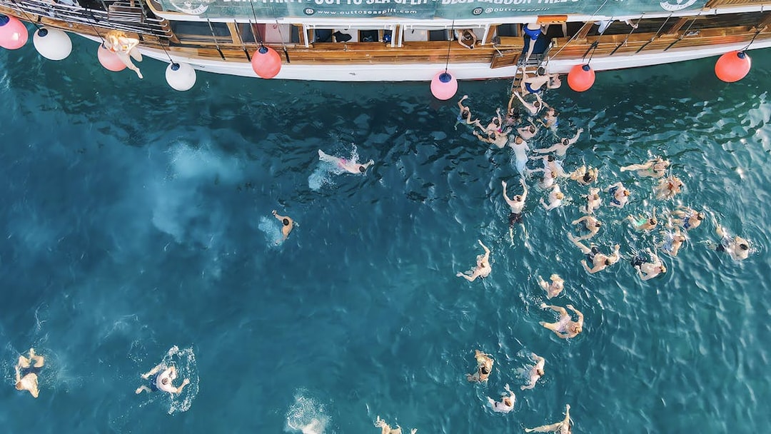 Participants swimming at a boat party in the Blue Lagoon, Split, Croatia.