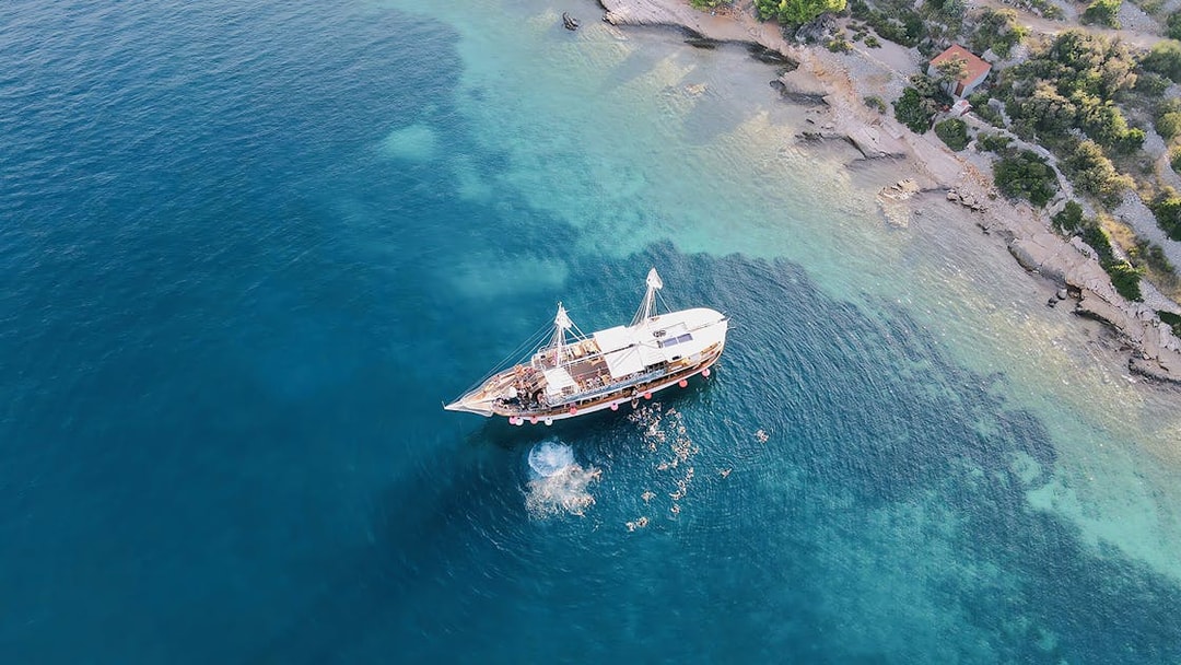 Boat party at Blue Lagoon, Split, Croatia with people swimming nearby.