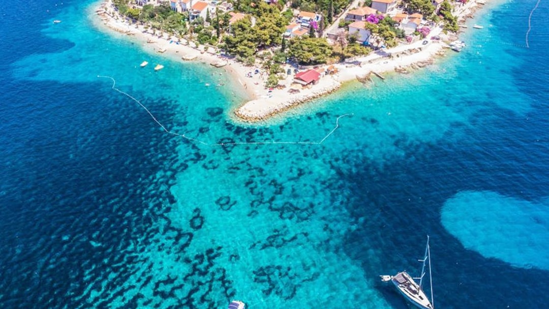 Aerial view of Duga Bay with boats and coastal village.