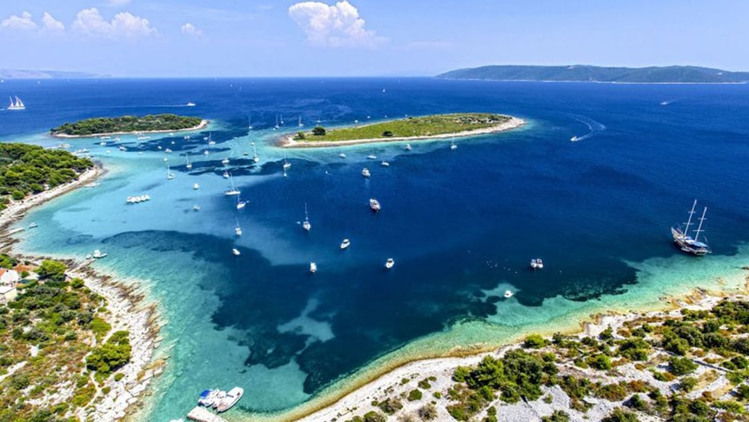 Boats anchored near islands in Blue Lagoon, Croatia, part of the Small Group 3 Islands tour.