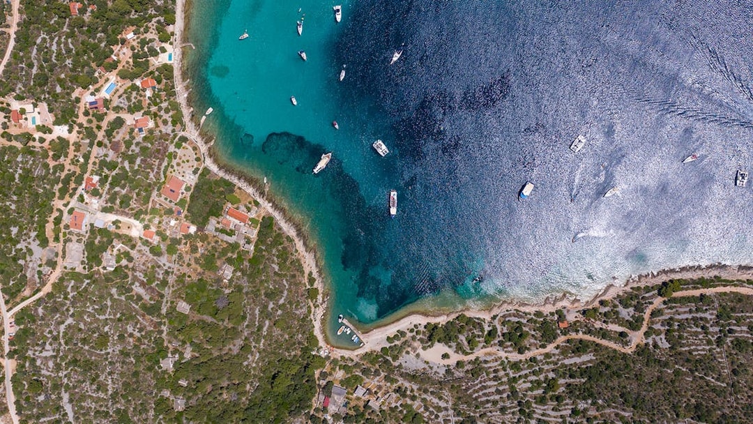Aerial view of boats in Blue Lagoon, Split, with coastline and greenery.