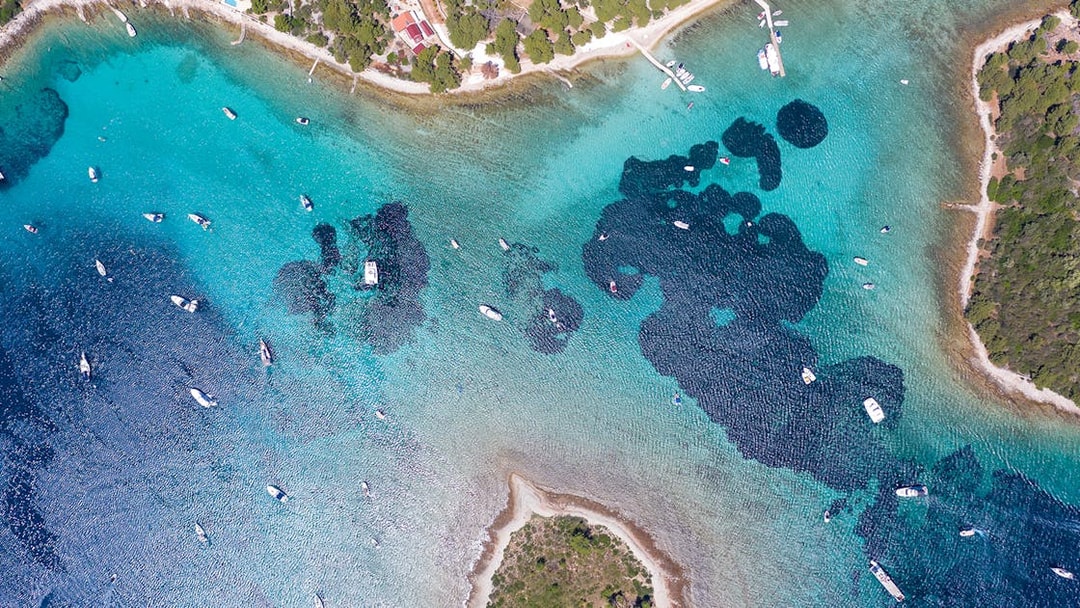 Aerial view of boats in the Blue Lagoon near Split, Croatia, surrounded by clear turquoise waters.