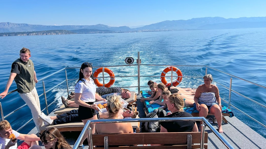 Group enjoying a boat cruise on the Blue Lagoon Šolta with scenic views of the Adriatic Sea.