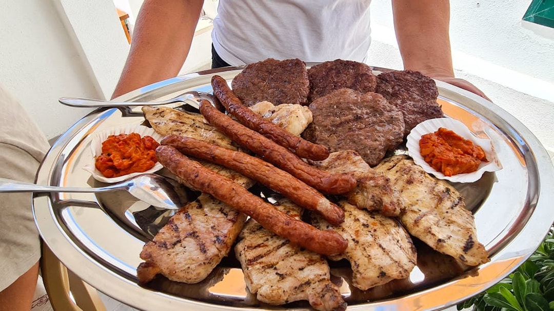 Grilled meats and ajvar served on a platter during Split boat tour lunch.