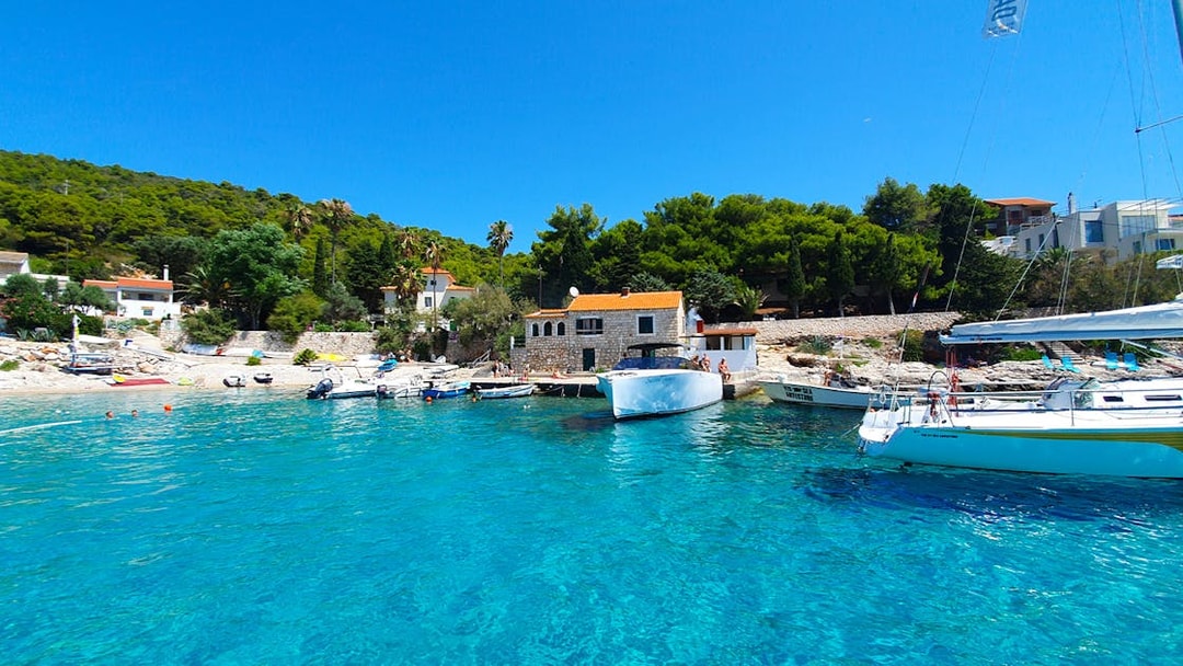 Boats docked at a scenic bay on the Split full-day tour to Blue Cave, Vis, and Hvar.