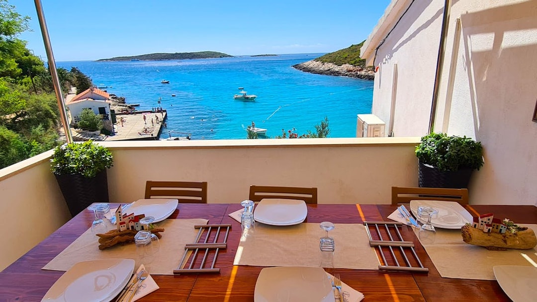 Dining table overlooking the sea on a boat tour from Split to Blue Cave, Vis, and Hvar.
