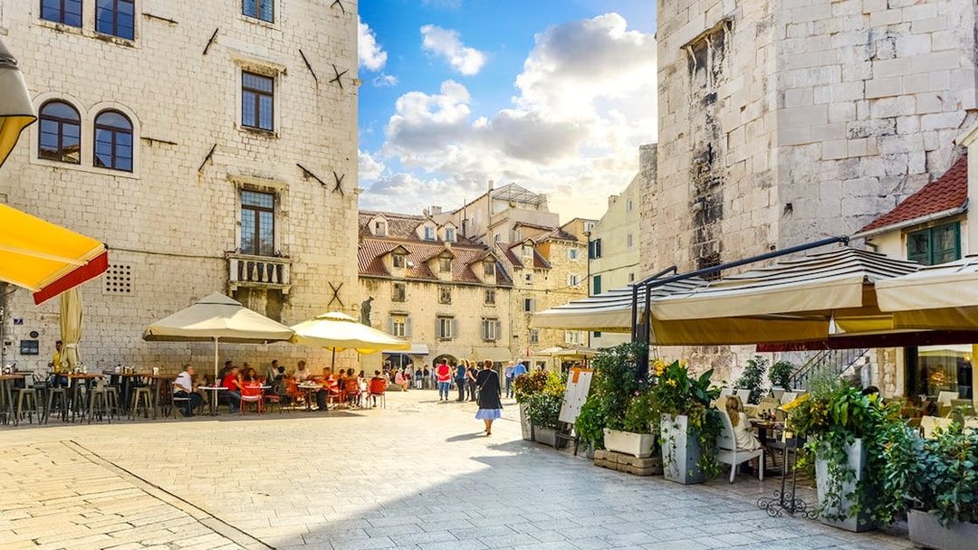 Diocletian's Palace courtyard with cafes and tourists in Split's Old Town.