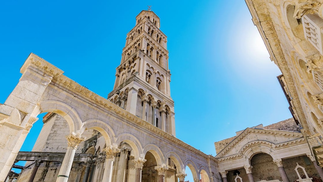 Diocletian's Palace bell tower and arches in Split, Croatia, under a clear blue sky.