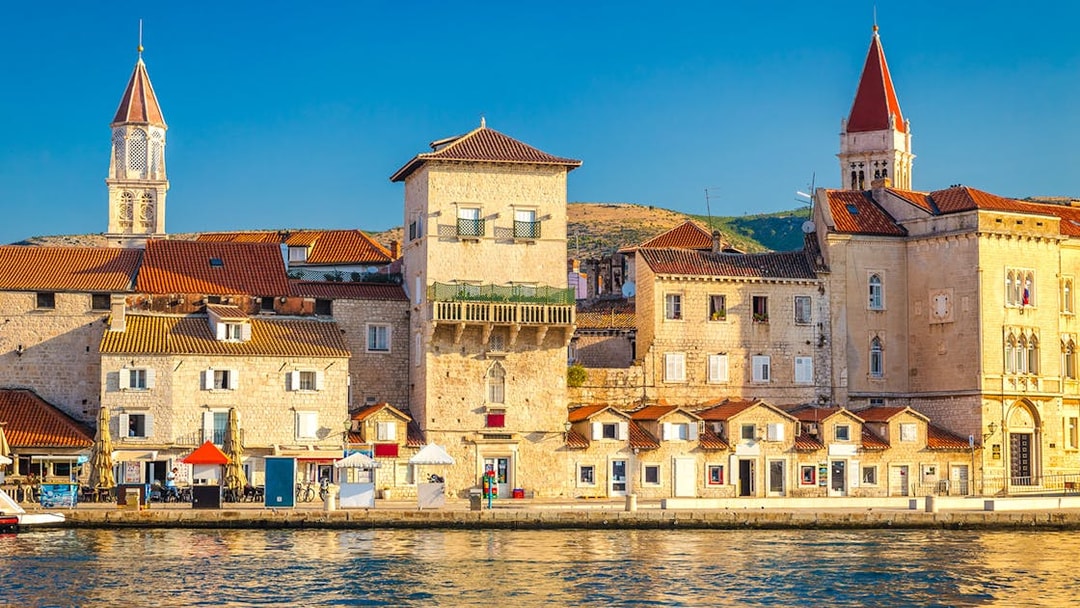 Promenade along the waterfront in the Old Town of Trogir, Croatia, with historic buildings.
