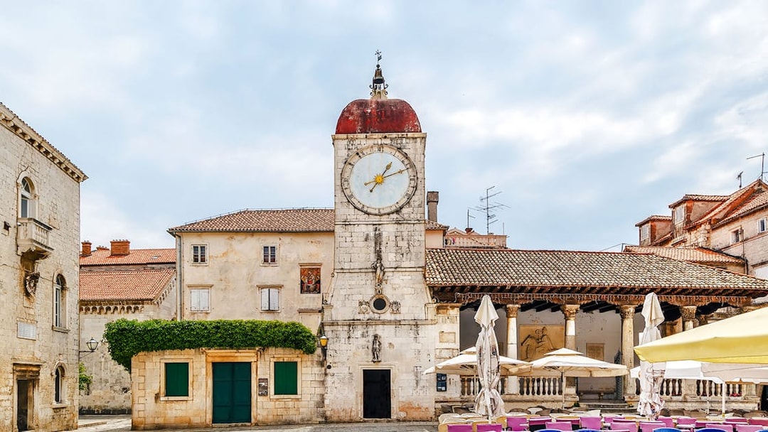 Loggia and clock tower in Trogir, Croatia, with surrounding historic buildings.