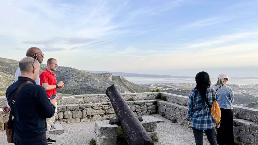 Tourists viewing Split from a historic fort with a cannon, part of the Split Panoramic Bus Tour.
