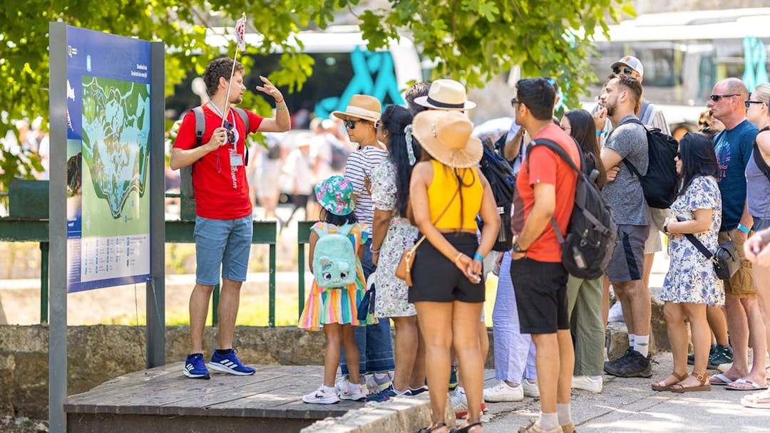 Tour group listening to a guide at Krka Waterfalls, Croatia.