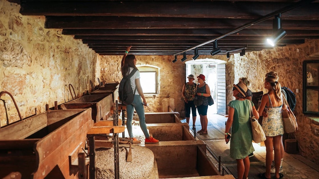Visitors exploring a historic stone building on the Krka Waterfalls Tour from Split.