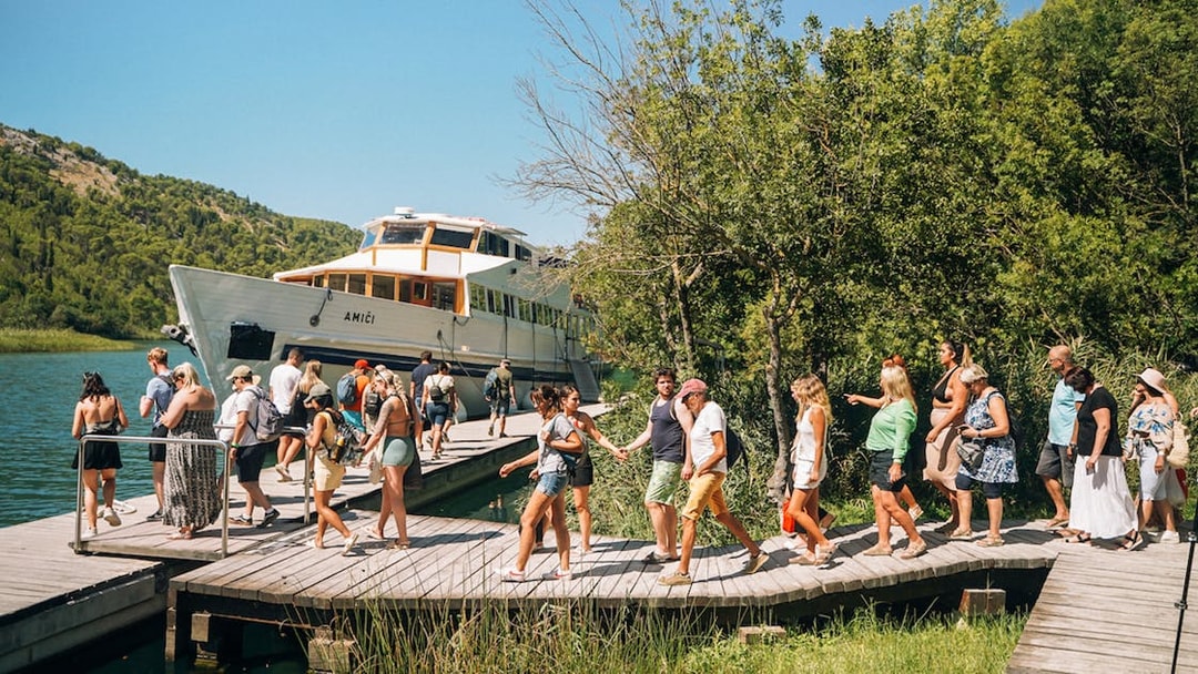 Tourists boarding a boat at Krka National Park during a Split wine tasting tour.