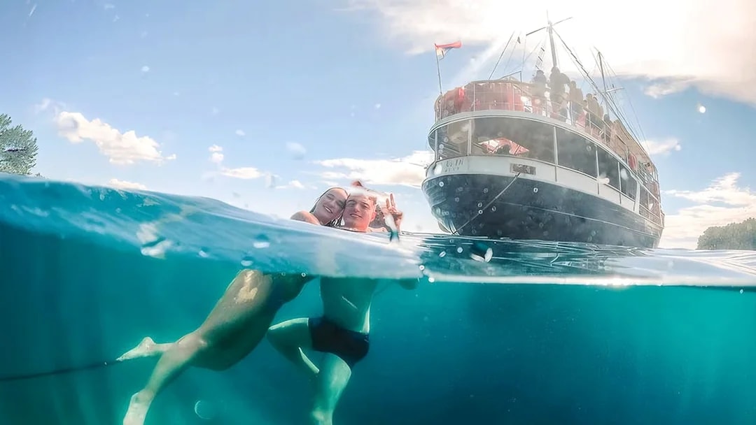 Guests swimming near a boat during Split Party Cruise.