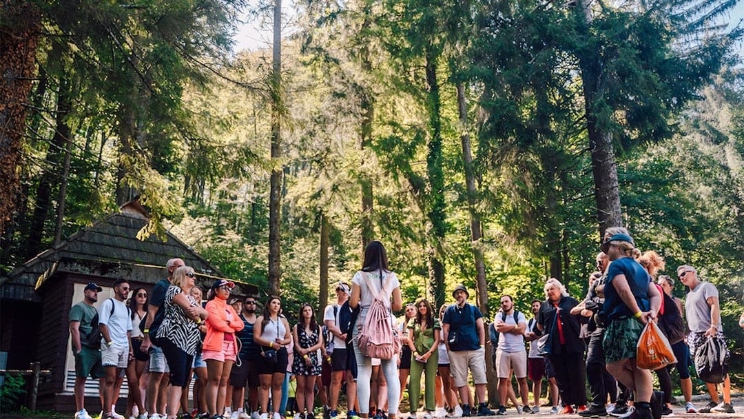 Tour group listening to a guide in Plitvice Lakes National Park forest.