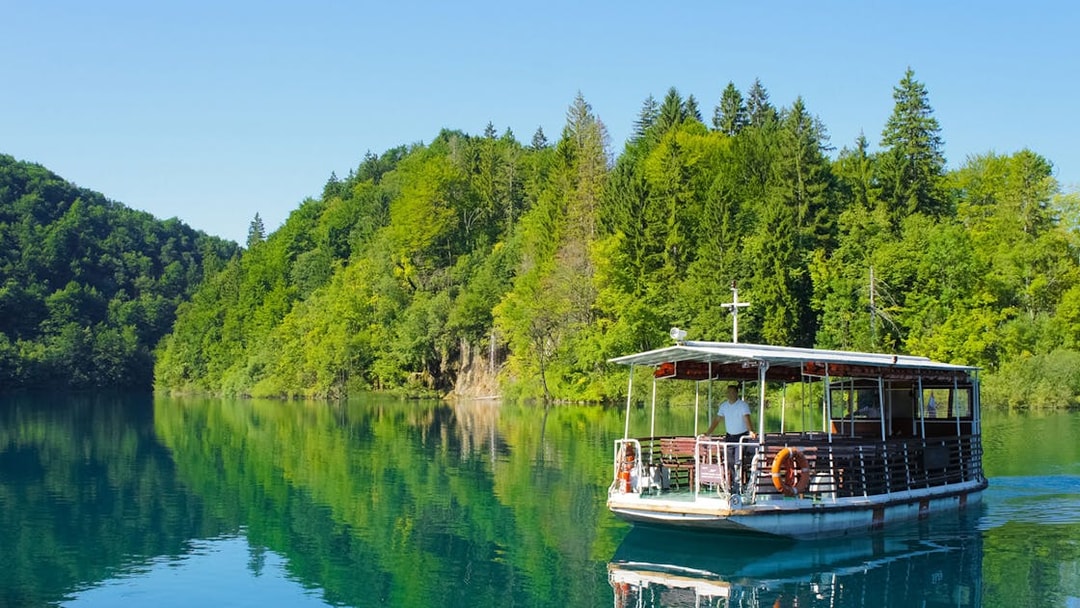 Boat ride on a lake surrounded by lush forest at Plitvice Lakes National Park.