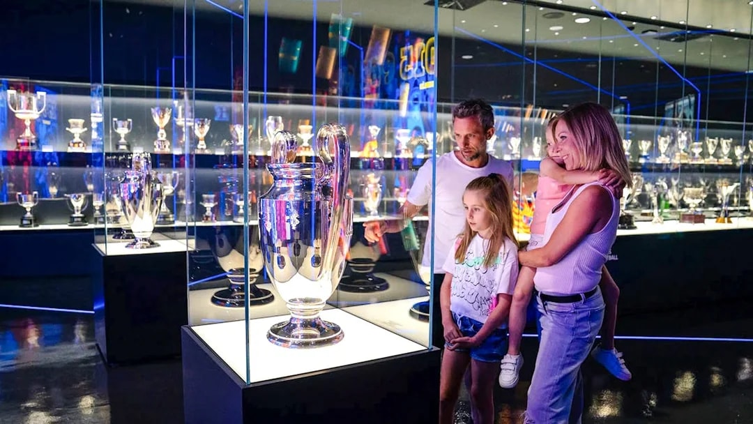 Family exploring trophy displays at Spotify Camp Nou Barça Museum.