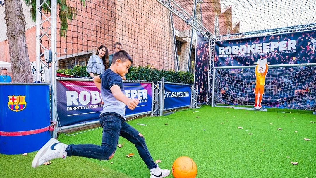 Child playing soccer at the Robokeeper exhibit, Spotify Camp Nou Barça Museum.