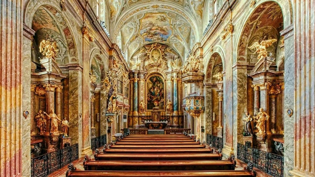 Interior of St Anne's Church with ornate arches and detailed frescoes.