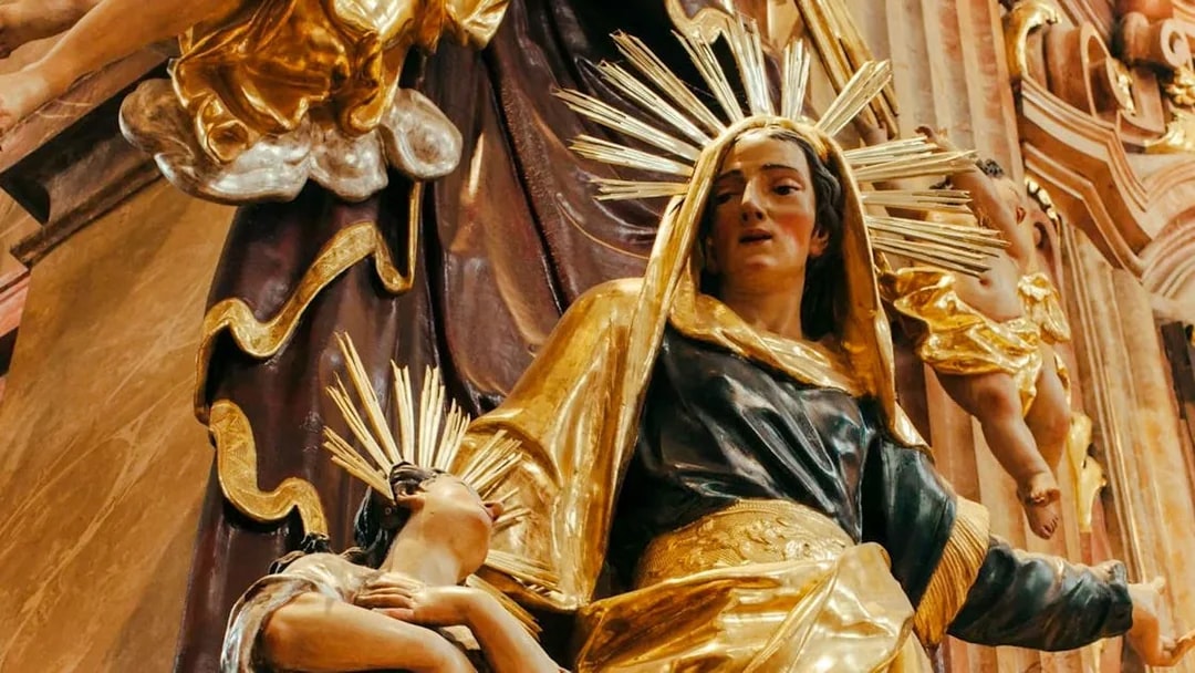Statue of a woman and child with golden halos inside St Anne's Church.