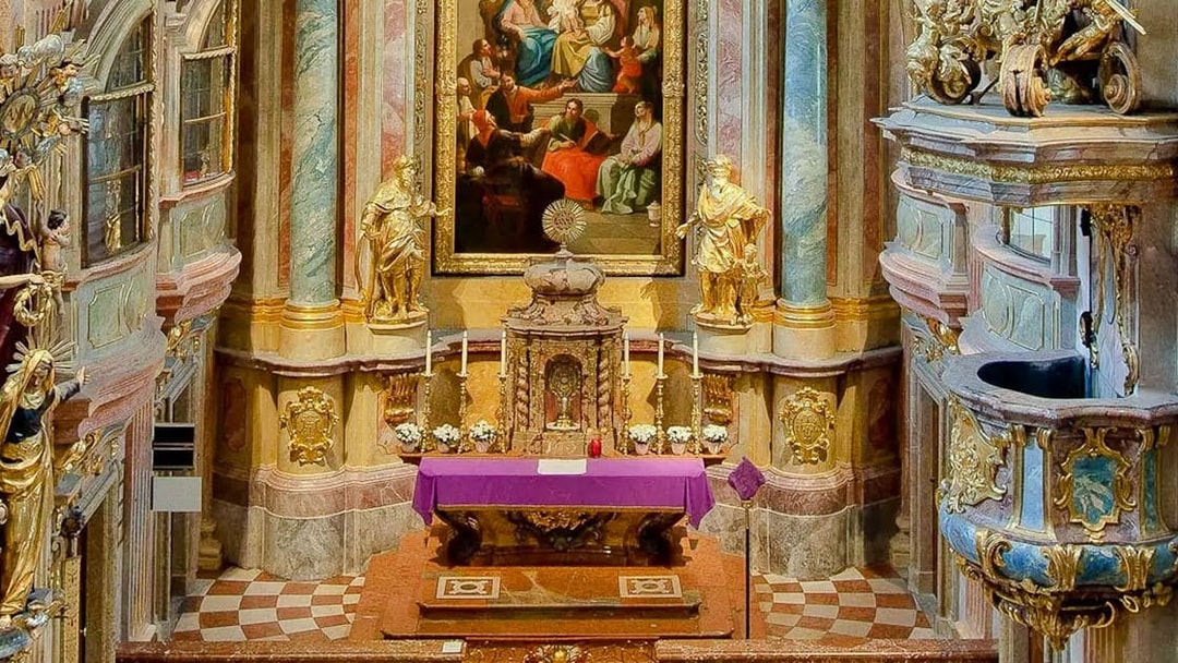 Altar and ornate interior of St Anne's Church with religious artwork and statues.