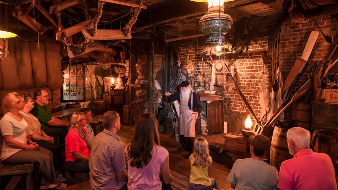 Tour guide narrating ghost stories to visitors in a dimly lit room, St. Augustine.