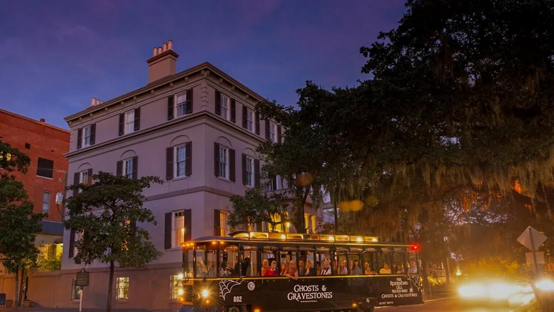 St. Augustine Ghosts & Gravestones tour trolley at dusk near historic building.