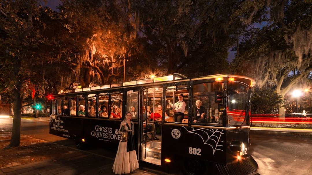St. Augustine Ghosts & Gravestones tour trolley at night with passengers and guide.