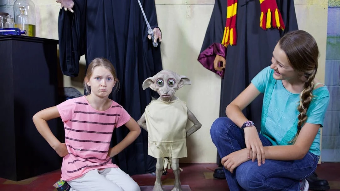 Children posing with a wax figure of a house-elf at St. Augustine Potter's Wax Museum.