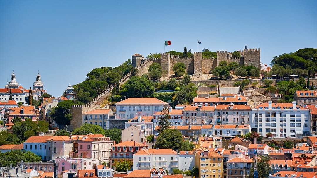 St. George’s Castle overlooking Lisbon with historic buildings in the foreground.
