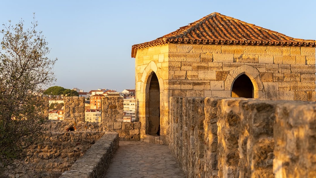 St. George’s Castle stone walkway and tower in Lisbon at sunset.
