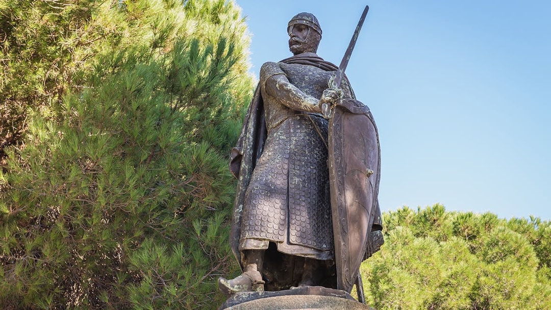 Statue of a medieval knight with sword and shield at St. George Castle, Lisbon.