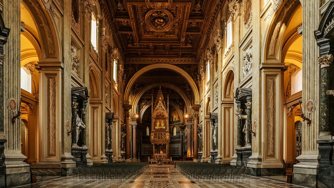 St. John Lateran Basilica interior with ornate ceiling and altar, Rome, Italy.