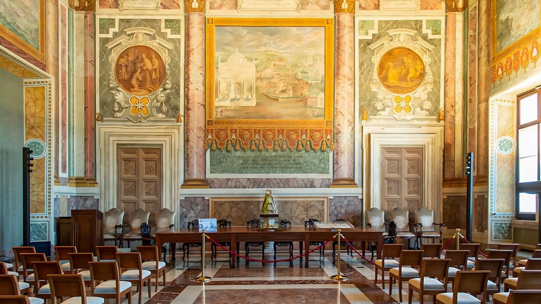 Interior of St. John Lateran with ornate frescoes and seating area for audio guide tour.