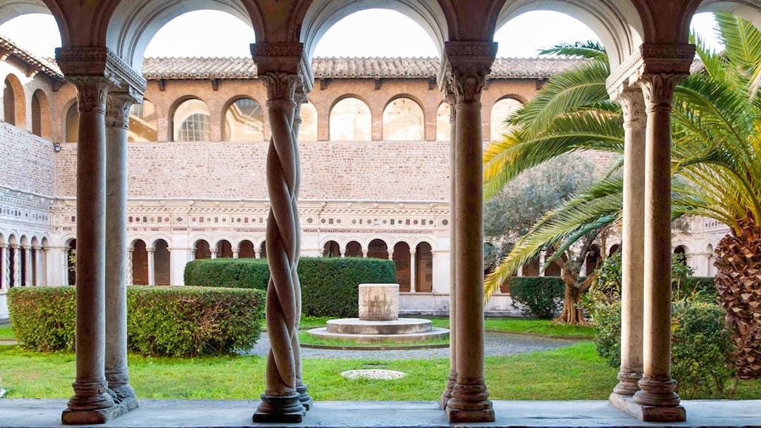 Cloister view at St. John Lateran Basilica, Rome, with arches and garden.