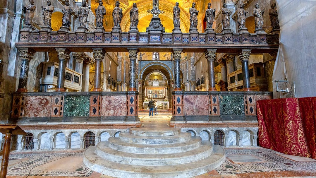 Interior view of St. Mark's Basilica altar with ornate columns and statues, Venice, Italy.