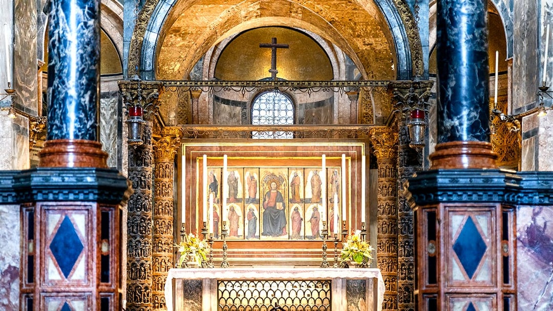 Interior of St. Mark’s Basilica altar with ornate columns and religious artwork, Venice.