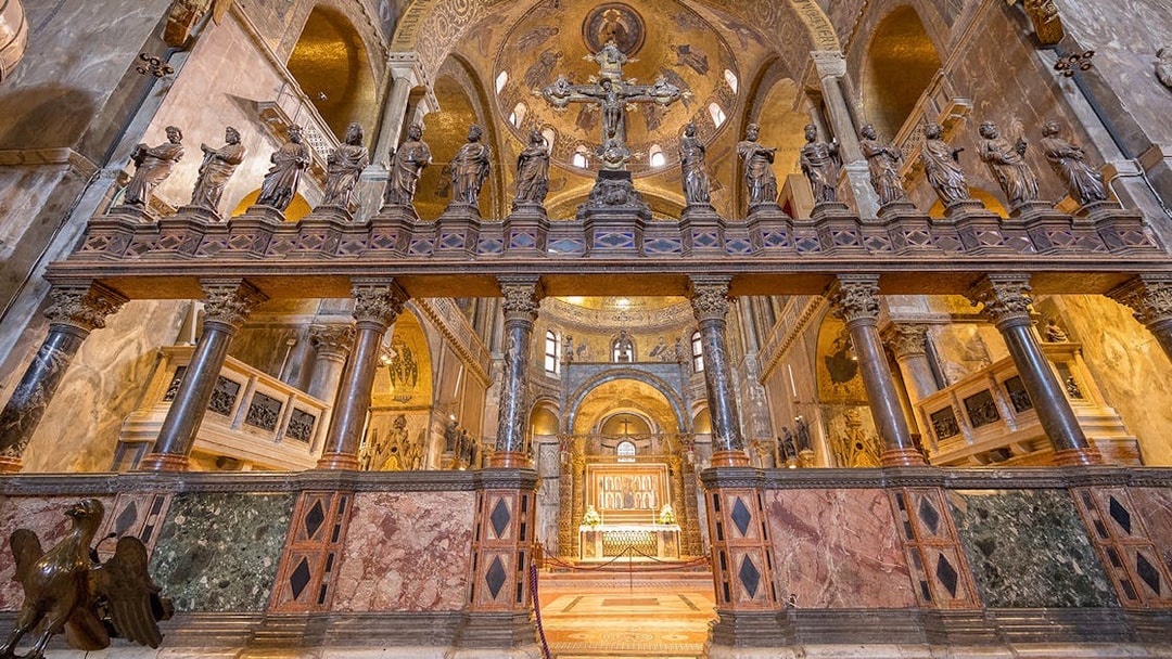 St. Mark's Basilica interior with ornate columns and statues, Venice, Italy.