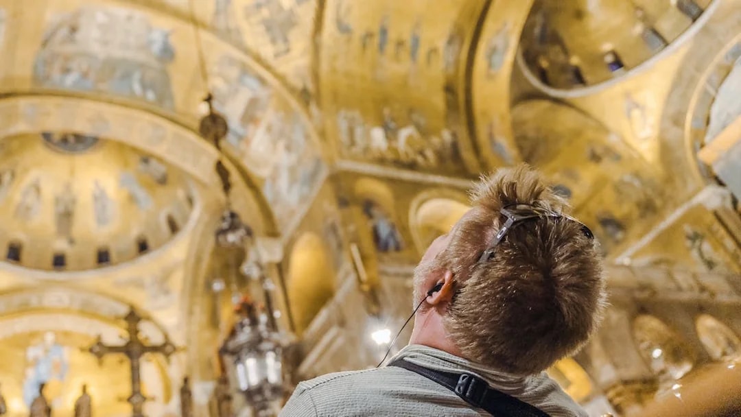 Visitor admiring golden mosaics inside St. Mark's Basilica during exclusive after-hours tour.