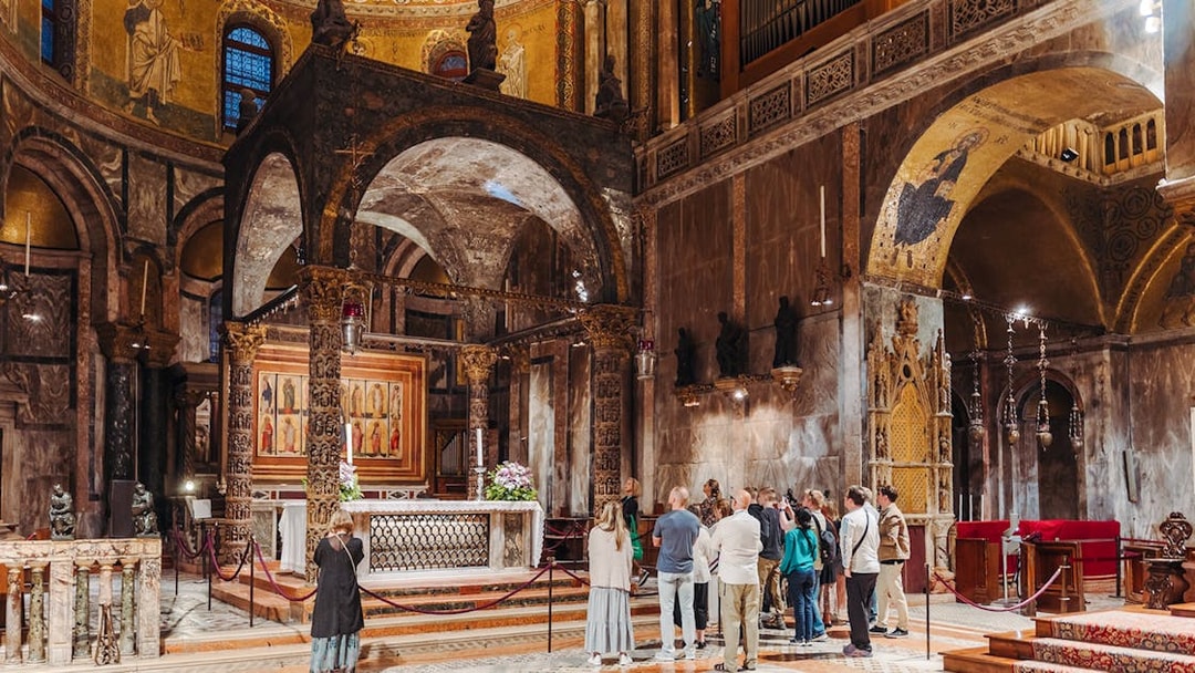 Visitors on an exclusive tour inside St. Mark's Basilica, Venice, admiring the ornate interior.