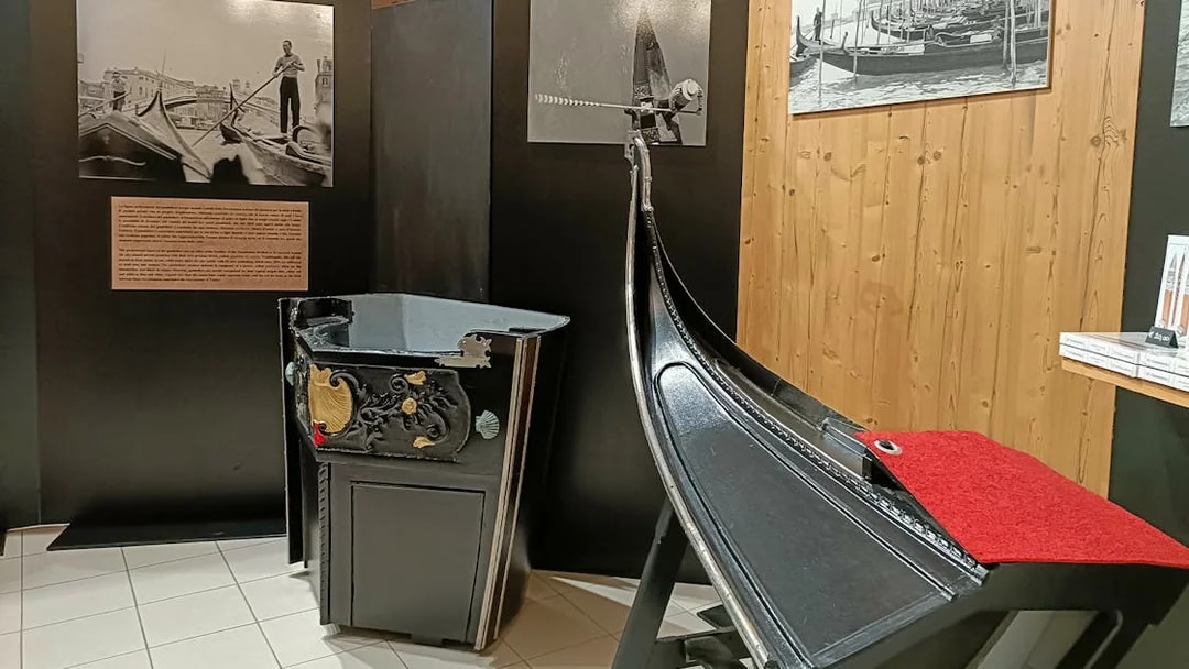 Gondola exhibit at Doge's Palace, Venice, featuring historical photos and decorative details.