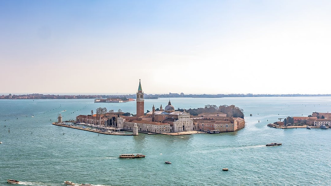Aerial view of San Giorgio Maggiore Island in Venice, Italy, with boats in the lagoon.
