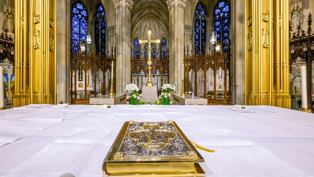 Altar view inside St. Patrick's Cathedral with ornate Bible and golden cross.