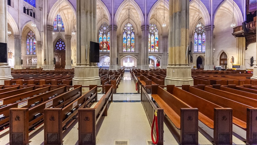 St. Patrick's Cathedral interior with stained glass windows and wooden pews, New York City.