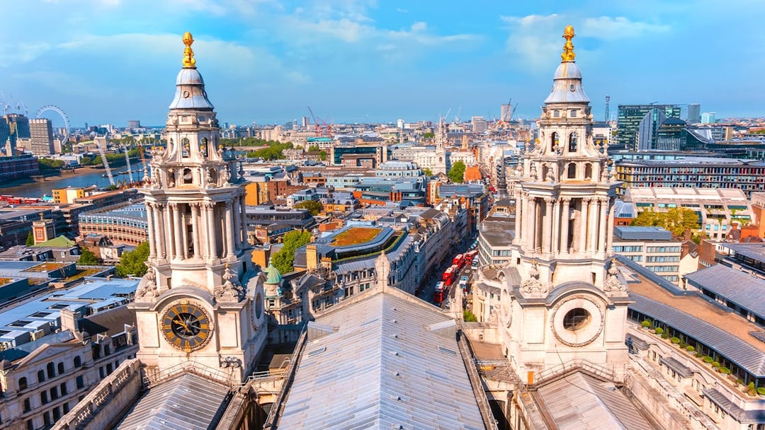 Aerial view from St Paul's Cathedral's Golden Gallery, showcasing twin baroque towers and London's skyline.