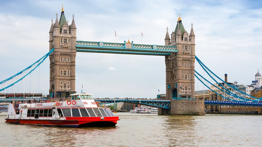 River cruise boat passing under Tower Bridge, London.