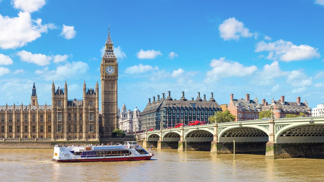 River cruise boat on the Thames near Big Ben and Westminster Bridge, London.