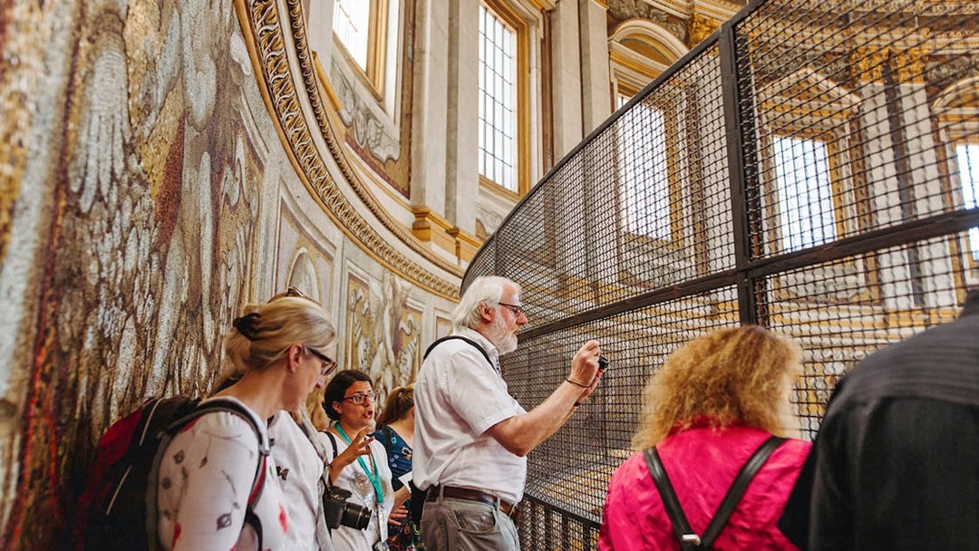 Tour group exploring the interior of St. Peter’s Basilica, focusing on detailed mosaics.