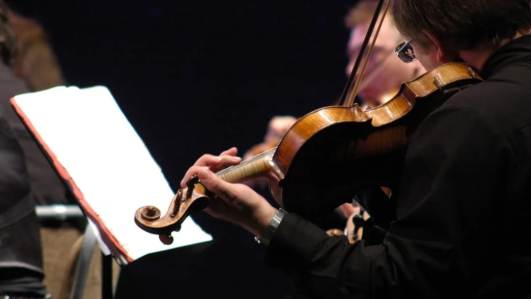 Musicians playing violins at St. Peter's Church concert in Vienna.